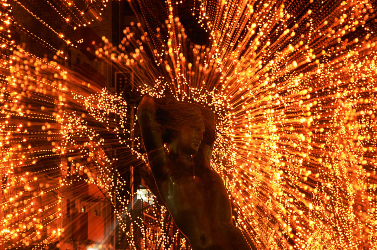 後光がさすブロンズ像 街並み 建物 夜景 Ganref