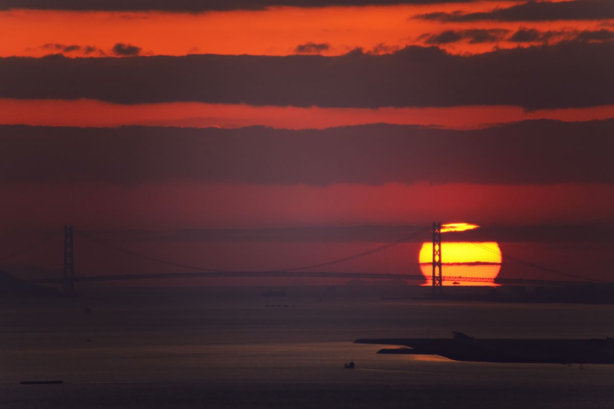 明石海峡大橋に沈むだるま夕陽 | GANREF